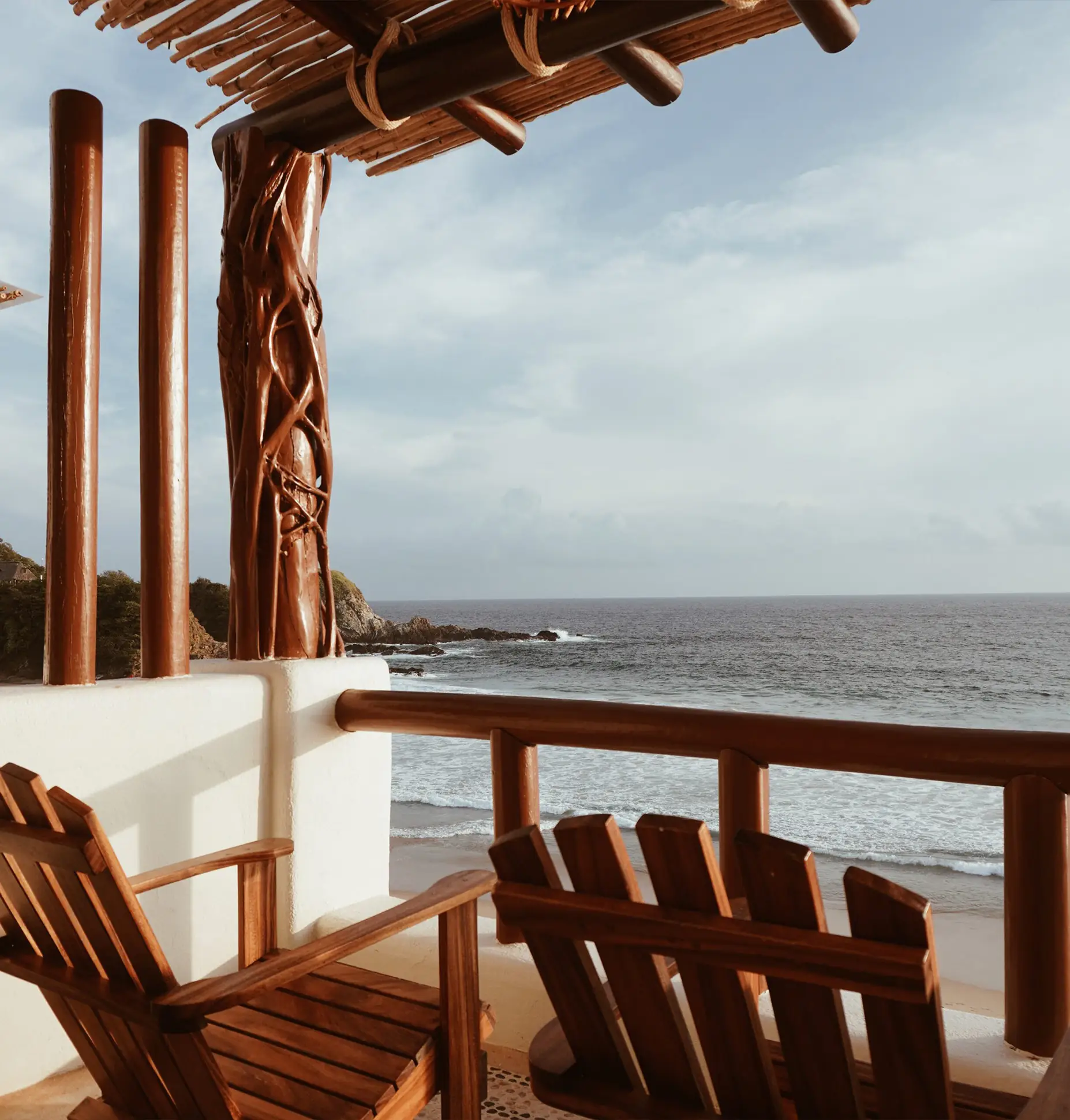 Terraza con sillas de madera y vista al mar