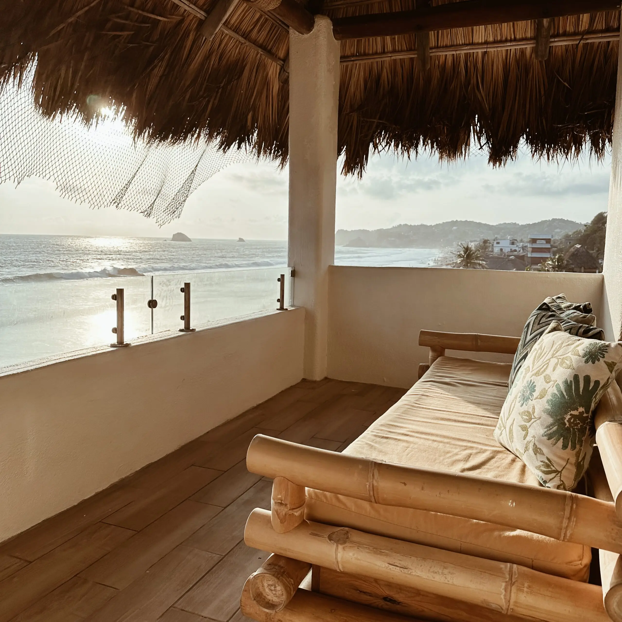 Terraza privada con camastro de bambú y vista al mar