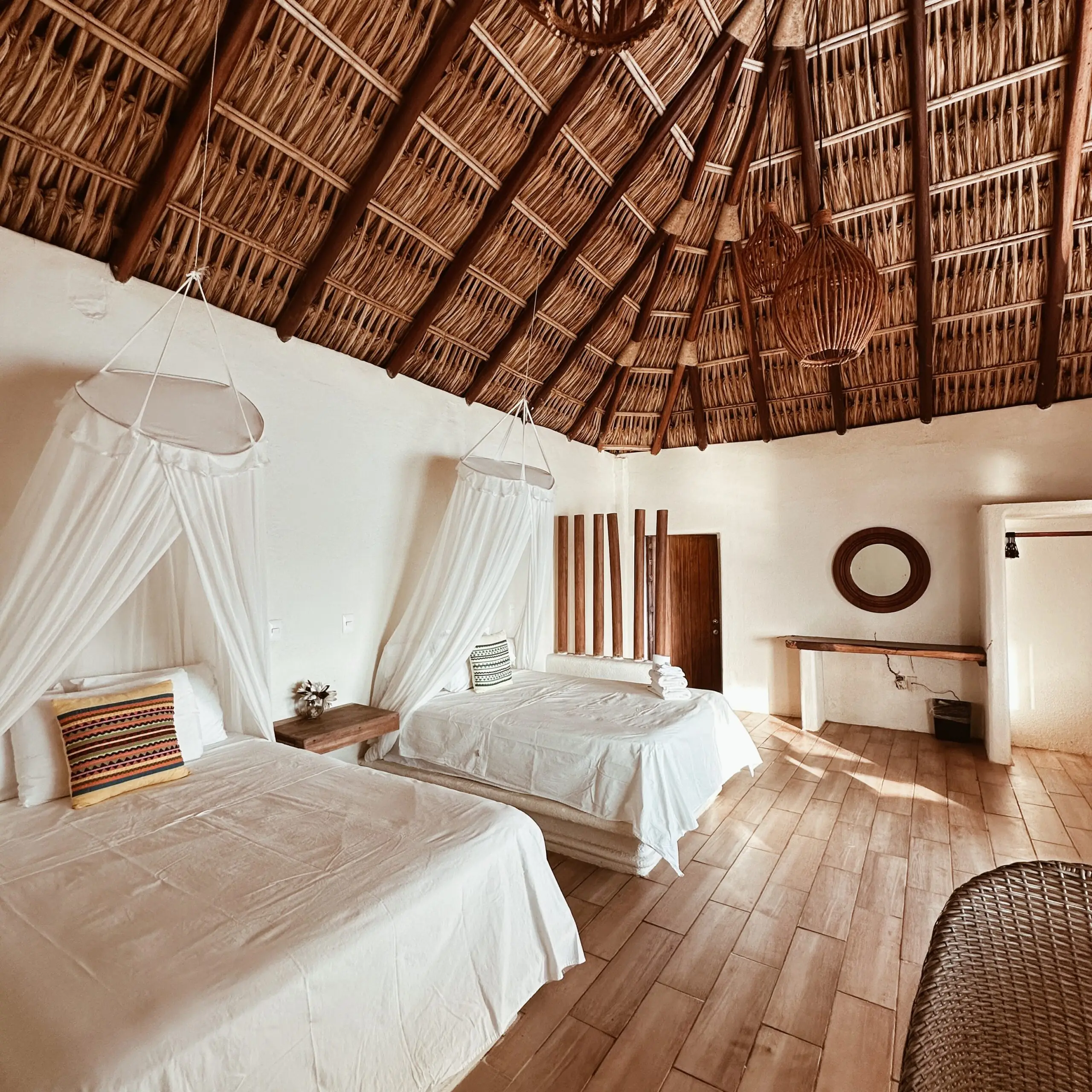 Cama king size con mosquitero bajo techo de palapa