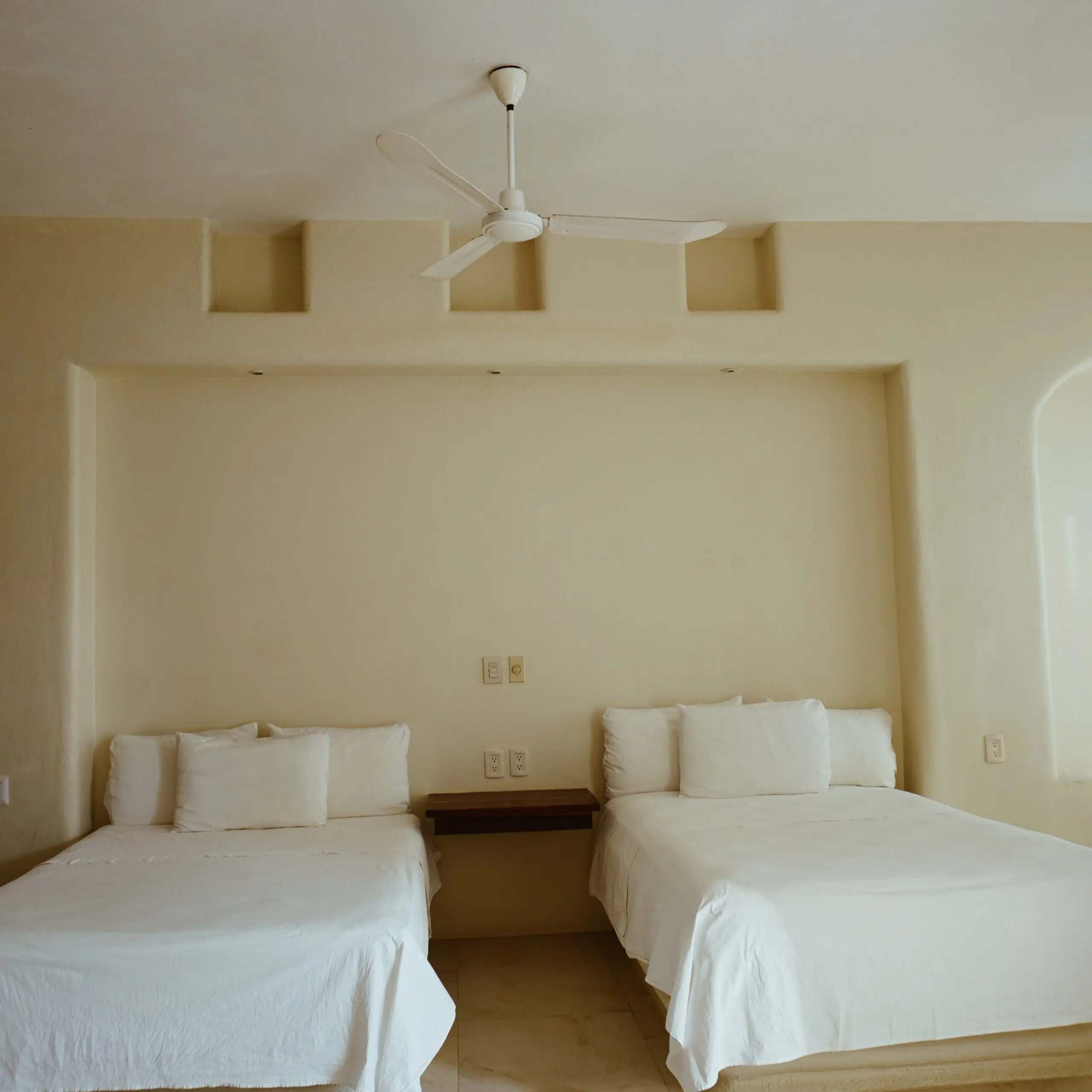 Dos camas matrimoniales con ropa de cama blanca